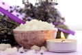 Large crystals of sea salt and lavender flowers, lit candle.