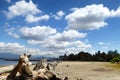 Large cumulous clouds rise over beach and sea by Vancouver