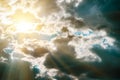 Large cumulus storm clouds and sun in the blue sky