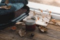 Large Cup of cappuccino on vintage brown background. Autumn, fall leaves, hot steaming cup of coffee and a warm scarf on wooden ta Royalty Free Stock Photo