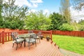 Large deck with dining space overlooking spacious back yard.