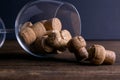 Large decorative glass tumbler, wine glass on a long stem, beautiful filled with wine corks lies on a wooden table. Corks are Royalty Free Stock Photo