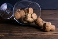 Large decorative glass tumbler, wine glass on a long stem, beautiful filled with wine corks lies on a wooden table. Corks are Royalty Free Stock Photo