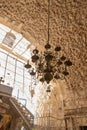 A large decorative lamp hangs from a ceiling in the interior of the St. Jacobs orthodox cathedral Jerusalem in Christian