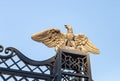 A large decorative metal eagle with outstretched wings on the gate of the upper terrace of the Bahai Garden in the rays of the