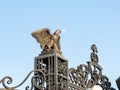 A large decorative metal eagle with outstretched wings on the gate of the upper terrace of the Bahai Garden in the rays of the