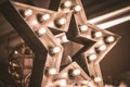 Large decorative retro star with lots of burning lights on grunge concrete background. Beautiful decor, modern design element