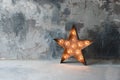 Large decorative retro star with lots of burning lights on grunge concrete background. Beautiful decor, modern design Royalty Free Stock Photo