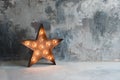 Large decorative retro star with lots of burning lights on grunge concrete background. Beautiful decor, modern design