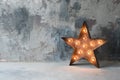 Large decorative retro star with lots of burning lights on grunge concrete background. Beautiful decor, modern design Royalty Free Stock Photo