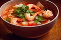 Large deep plate with tom yam soup with delicious orange shrimp