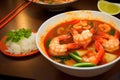 Large deep plate with tom yam soup with delicious orange shrimp