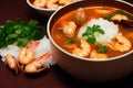 Large deep plate with tom yam soup with delicious orange shrimp