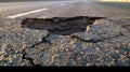 Large deep pothole an example of poor road maintenance due to reducing local council repair budgets. Royalty Free Stock Photo