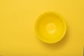 A large deep yellow bowl on a yellow background.