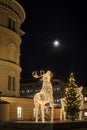 Large deer sculptures made of led lights, decorated Christmas tree and the shining moon Royalty Free Stock Photo