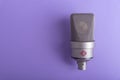 Large diaphragm condenser studio microphone Neumann tlm 103 on purple background.