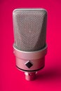 Large diaphragm condenser studio microphone. On a red background. Royalty Free Stock Photo