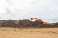 Large diesel mechanical excavator digging earth machine at excavation working in road construction.