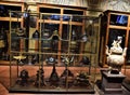 A large display case placed in the center of a room in Villa Stibbert, in Florence, contains dozens of ancient helmets, very diffe