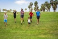 Large diverse group of active children running together in an outdoor park