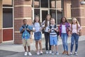 Large, diverse group of kids leaving school at the end of the day. School friends walking together and talking together on their w Royalty Free Stock Photo