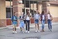 Large, diverse group of kids leaving school at the end of the day. School friends walking together and talking together on their w