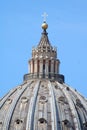 Large domed roof with a white cross placed at the top against a blue sky