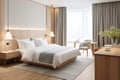 Large double bed in modern hotel room, in light colors