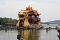 Large dragon boats packed with tourists cruise the waters of the