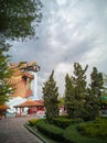 A large dragon building in the garden while the sky is near to rain