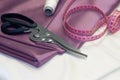 Large dressmaking scissors and pink measuring tape
