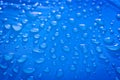 Large drops of water on a blue textile with a waterproof effect. Water-repellent impregnation. Royalty Free Stock Photo