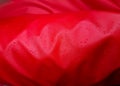 Large drops of water on a red textile with a waterproof effect. Water-repellent impregnation. Texture drops on the Royalty Free Stock Photo