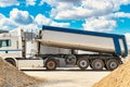 Large dump truck near the concrete factory. Car tonar for transportation of heavy bulk cargo. Provision of crushed stone and Royalty Free Stock Photo