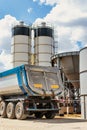 Large dump truck near the concrete factory. Car tonar for transportation of heavy bulk cargo. Provision of crushed stone and Royalty Free Stock Photo