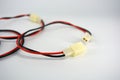 Large electric red black wires on 12V, 220V with white plastic dad connector and mom located on a white plastic background.