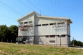 Large electrical company concrete white building coated with metal plates with multiple wires going in all direction