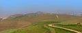 Large electrical transmission structures , rolling hills in California covered with mist