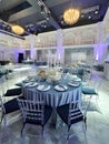 Elegant wedding reception hall with round tables and crystal chandeliers Royalty Free Stock Photo
