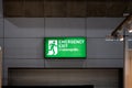 Large Emergency exit sign green light box is placed on the wall of exhibition hall. Thai Letter is Thai Language on the green Royalty Free Stock Photo