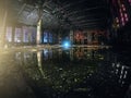 Large empty abandoned warehouse building or factory workshop at night with reflection in water, abstract ruins background Royalty Free Stock Photo