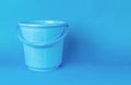 A large empty blue bucket on a blue background Royalty Free Stock Photo