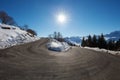 Large empty mountain road curve on Alps with snow on sides Royalty Free Stock Photo