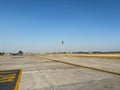 A large empty parking lot with a yellow line on the ground at an Indian airport.