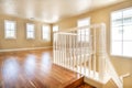 Large empty room with wood floor, molding and windows and stairs. Royalty Free Stock Photo