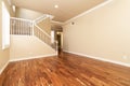 Large empty room with wood floor, molding and windows and stairs. Royalty Free Stock Photo