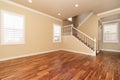 Large empty room with wood floor, molding and windows and stairs. Royalty Free Stock Photo