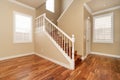 Large empty room with wood floor, molding and windows and stairs. Royalty Free Stock Photo