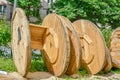 Large empty spools and reels of wooden cable drums stacked outdoor near houses